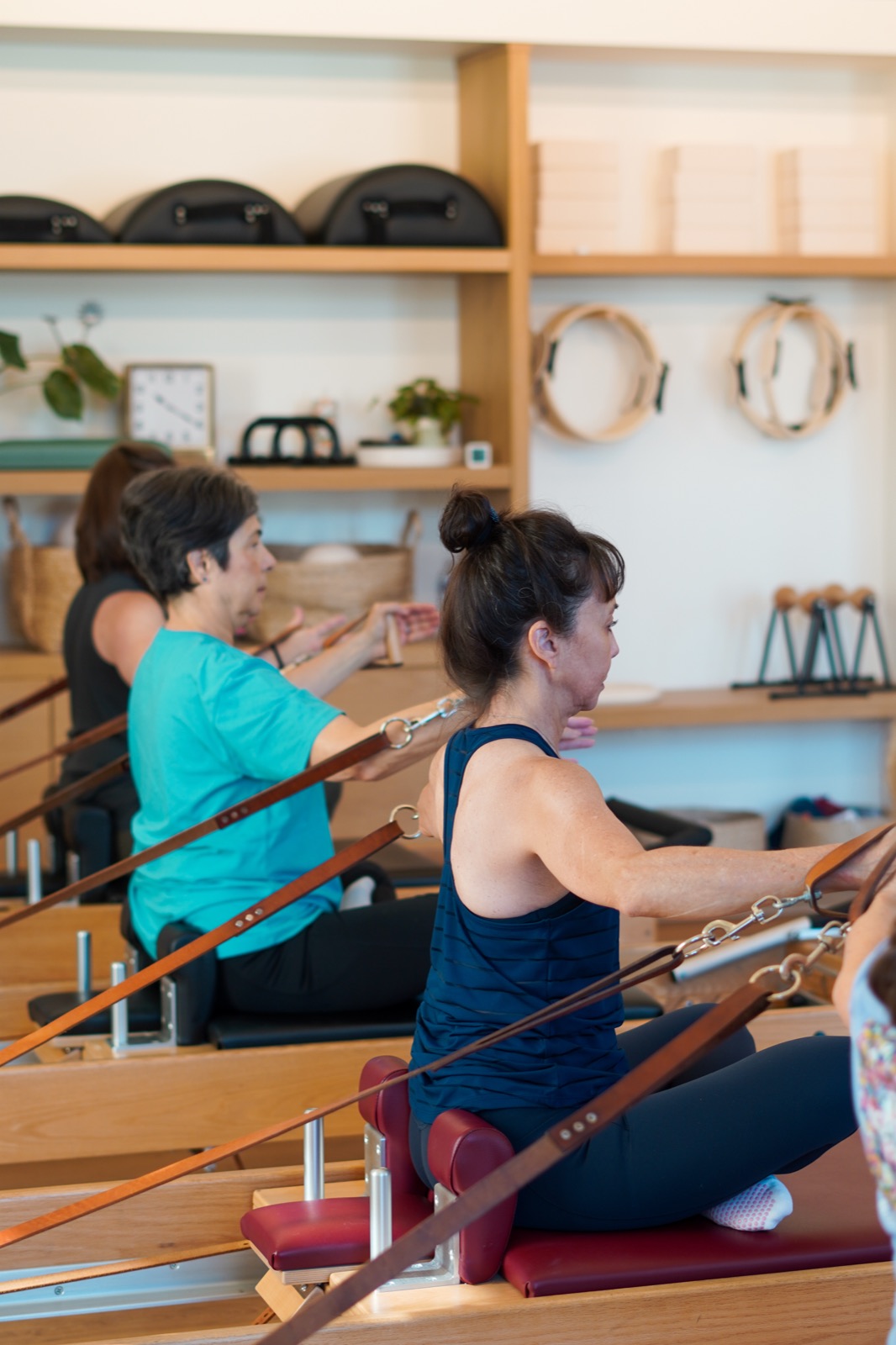 Participants practicing seated movements with reformer straps