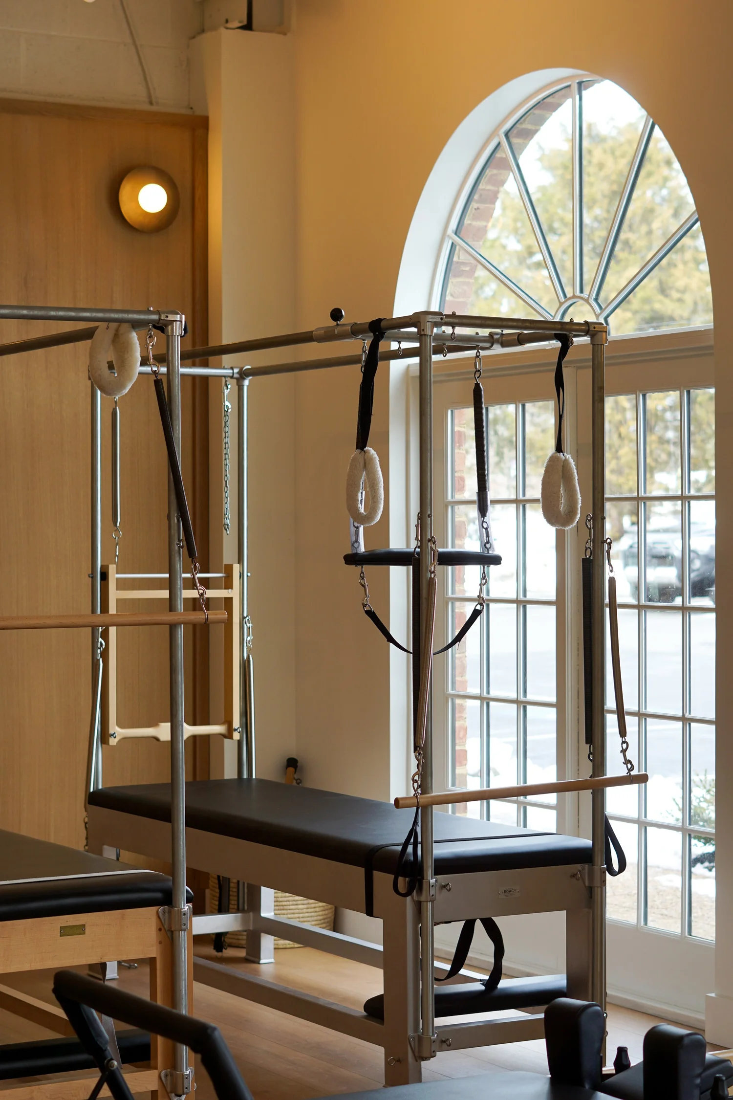 Pilates tower with springs and bars beside a studio window